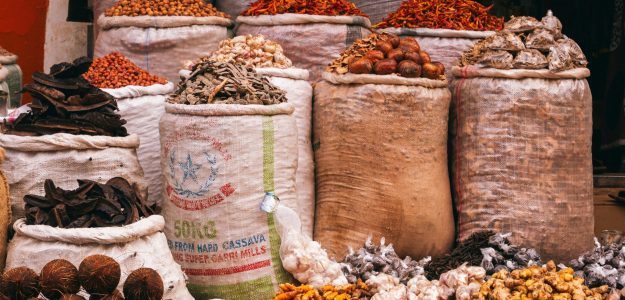Colorful variety of spices and herbs displayed in a bustling market in Jos, Nigeria.