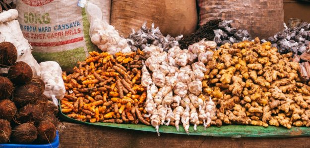 Colorful variety of spices and herbs displayed in a bustling market in Jos, Nigeria.